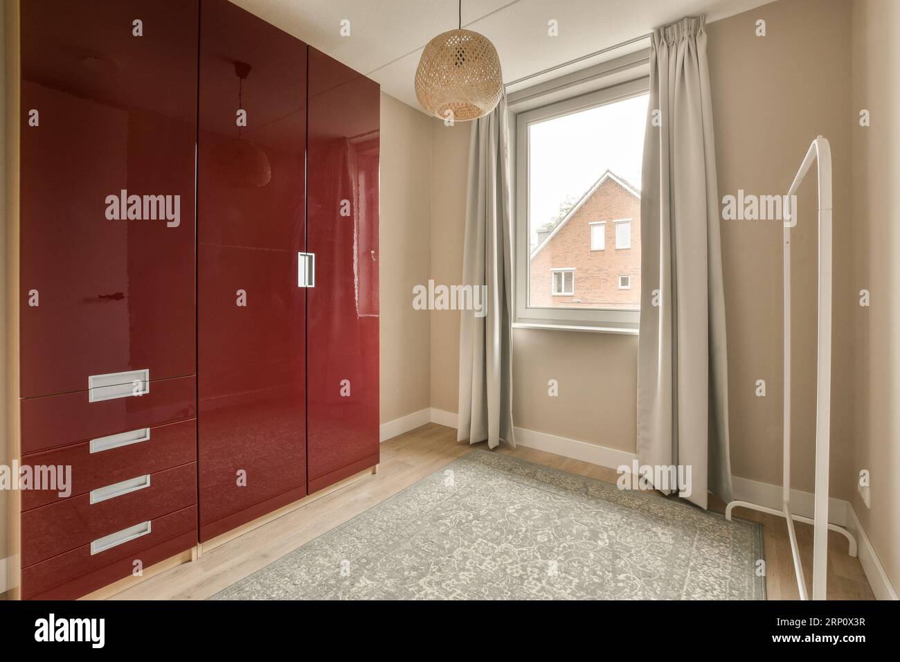 a bedroom with red cupboards and white curtains on the window sies, in ...