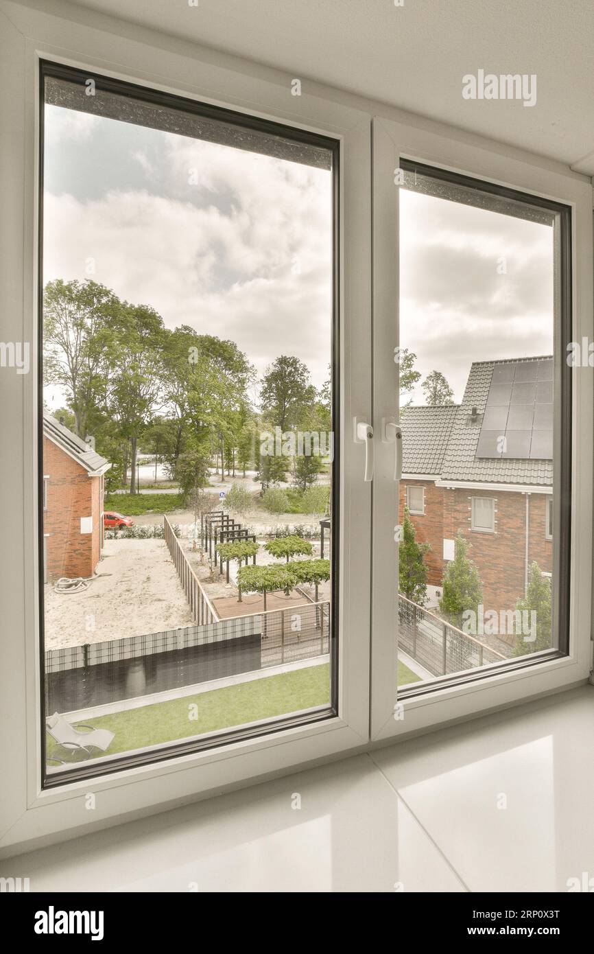 Out Window Panes an empty room with windows that look out onto the street, and houses ...