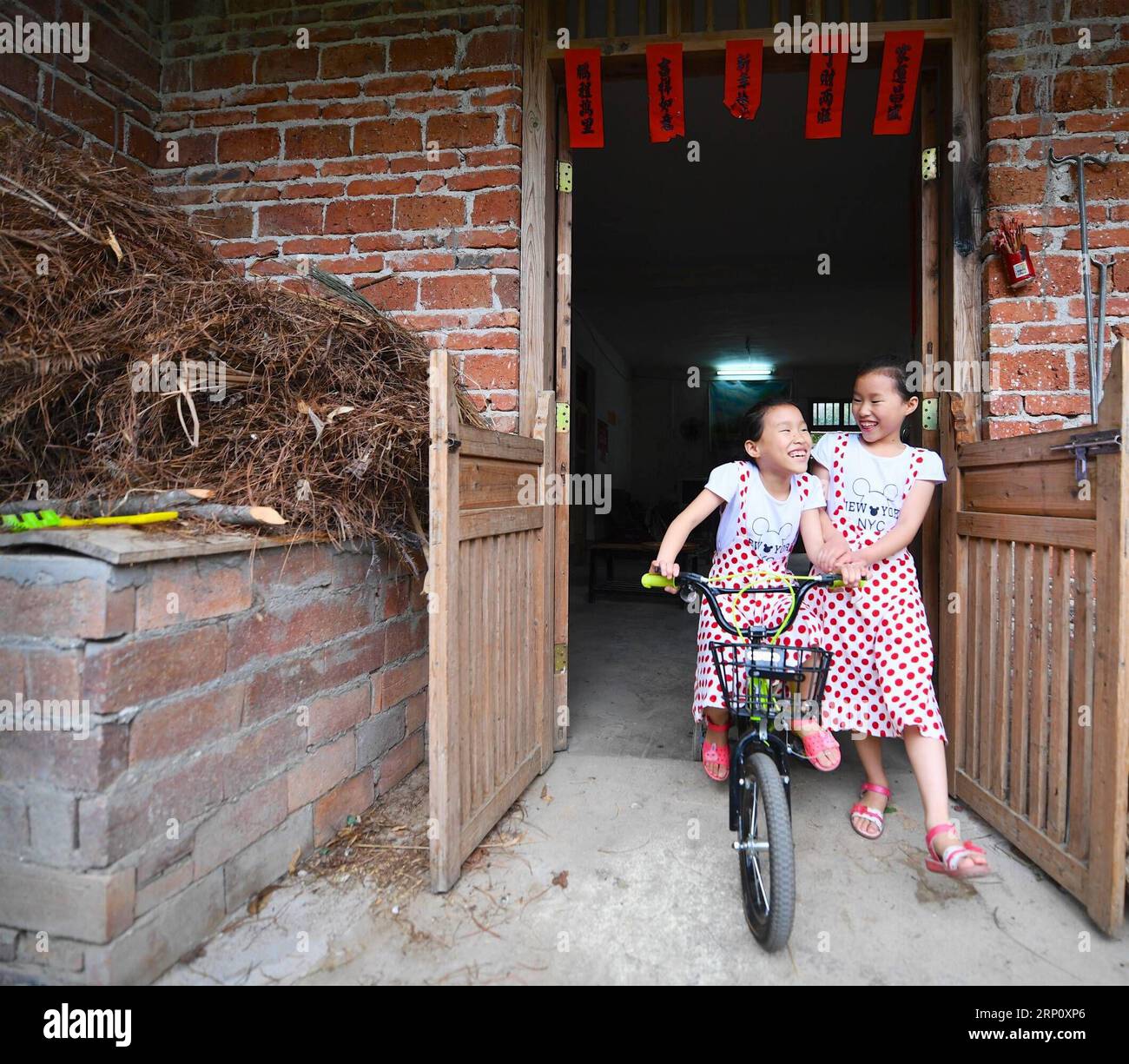 (180529) -- NANCHANG, May 29, 2018 -- Nine-year-old Zeng Jinrong (L) and her twin sister Zeng Jinyun are pictured at their home in Suolong Village of Yudu County, east China s Jiangxi Province, May 23, 2018. With about 1,000 residents, Suolong Village has 29 cases of multiple births, a high rate considering the modest population size. ) (lmm) CHINA-JIANGXI-VILLAGE-MULTIPLE BIRTHS-TWINS-LIFE (CN) HuxChenhuan PUBLICATIONxNOTxINxCHN Stock Photo