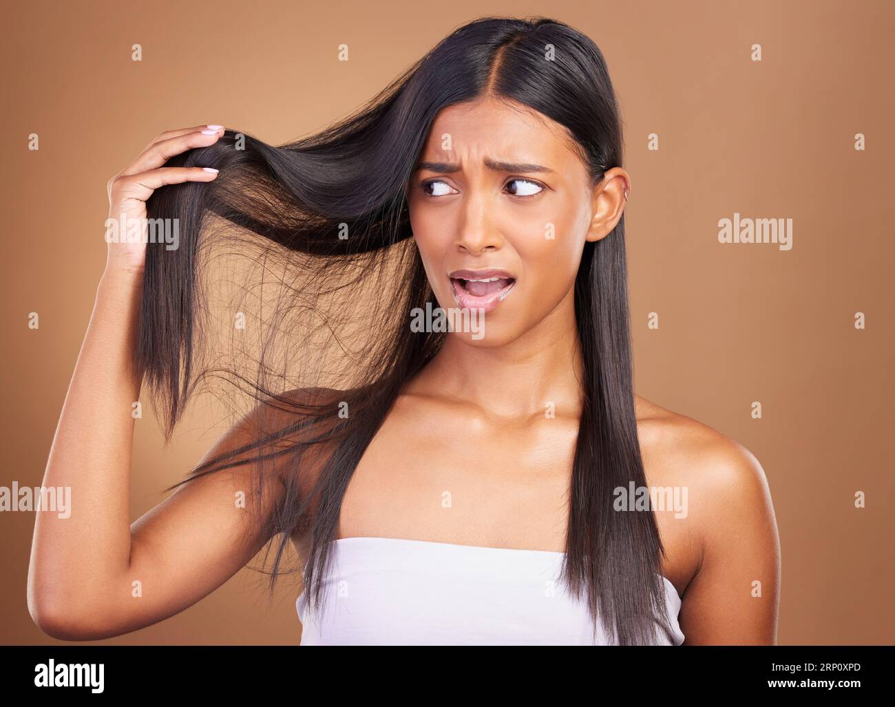 Beauty, disaster and unhappy woman with hair loss in studio worry, stress or anxiety for damage on brown background. Haircare, fail and lady model Stock Photo