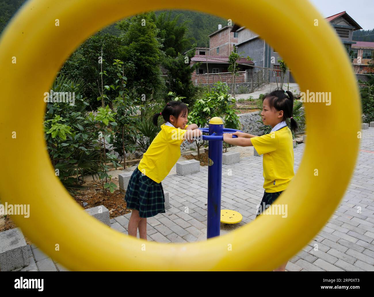 (180529) -- NANCHANG, May 29, 2018 -- Eleven-year-old Zhong Xiaofang (L) and her twin sister Zhong Xiaolan play with an outdoor fitness gear in Suolong Village of Yudu County, east China s Jiangxi Province, May 23, 2018. With about 1,000 residents, Suolong Village has 29 cases of multiple births, a high rate considering the modest population size. ) (lmm) CHINA-JIANGXI-VILLAGE-MULTIPLE BIRTHS-TWINS-LIFE (CN) PanxSiwei PUBLICATIONxNOTxINxCHN Stock Photo