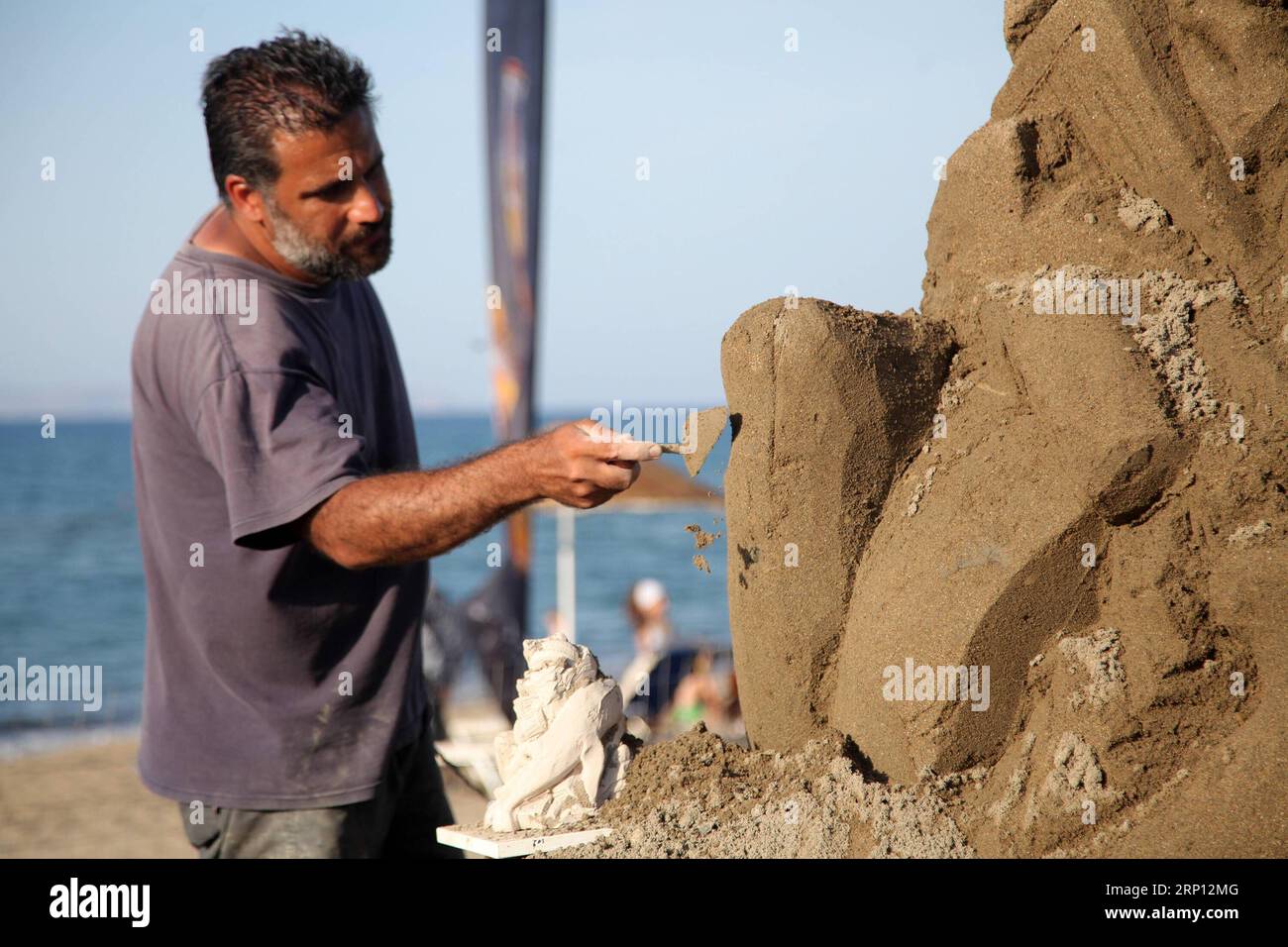 (180605) -- HERAKLION (GREECE), June 5, 2018 -- Greek sculptor Andreas Arapakis works on a sculpture at Ammoudara beach, Heraklion, Greece, June 5, 2018. Ammoudara Professional Sand Sculpting Festival is held here to raise public awareness on plastic pollution. ) GREECE-HERAKLION-SAND SCULPTING FESTIVAL StefanosxRapanis PUBLICATIONxNOTxINxCHN Stock Photo