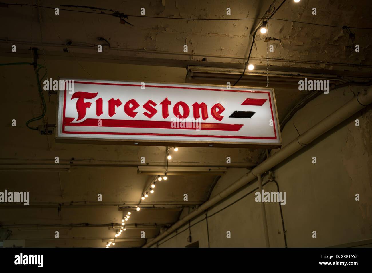 A closeup of an old illuminated sign for Firestone tires in an old workshop Stock Photo