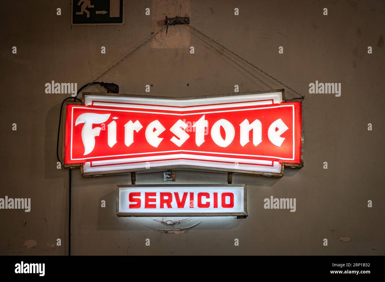 A closeup of an old illuminated sign for the Firestone service station in an old workshop Stock Photo