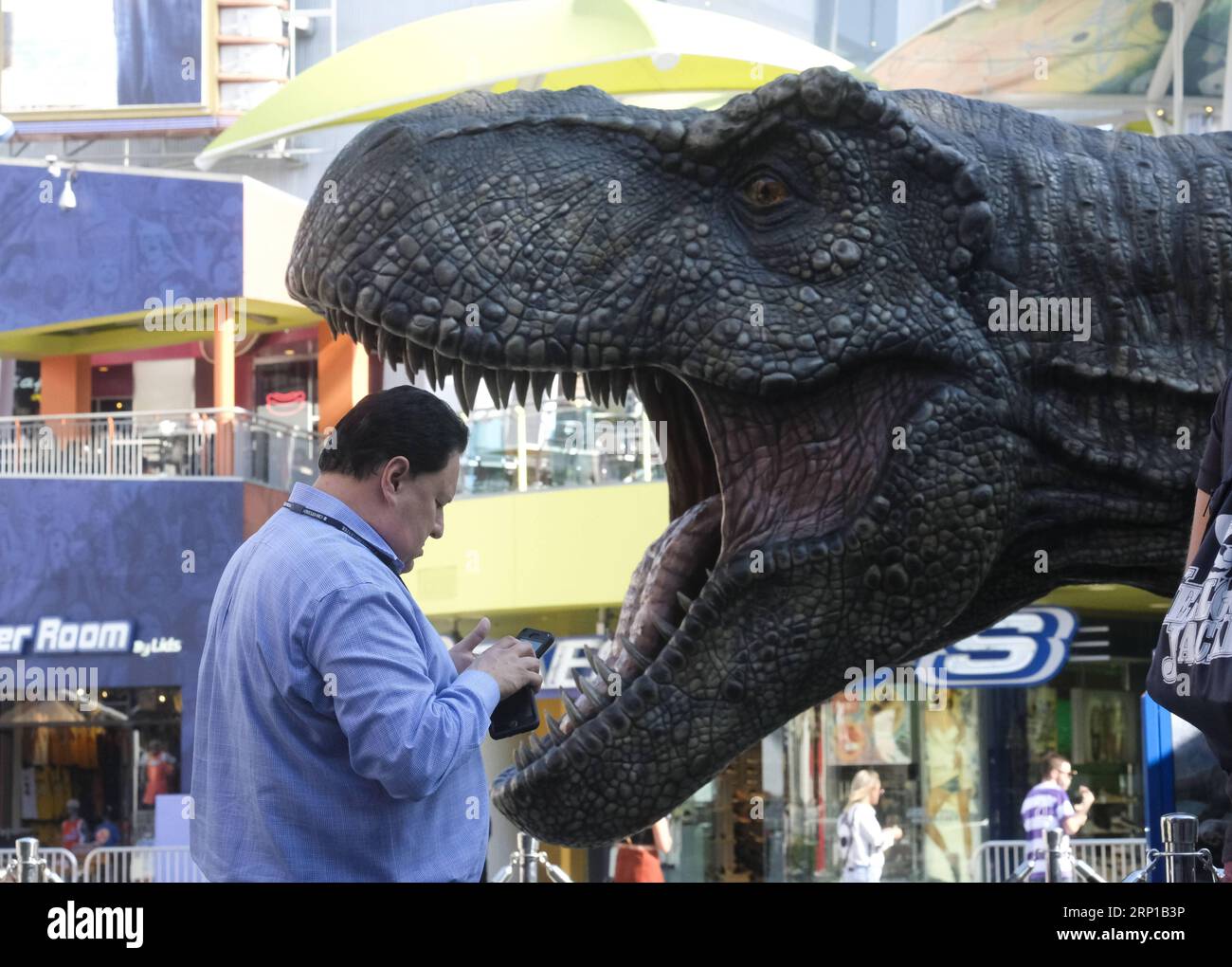 (180622) -- LOS ANGELES, June 22, 2018 -- A man passes by a giant Tyrannosaurus rex statue at Universal CityWalk in Los Angeles, the United States, on June 21, 2018. For the promotion of the screening of the new film Jurassic World: Fallen Kingdom on Universal Cinema Theatres, a colossal 3-ton Tyrannosaurus rex, a life-sized Gyrosphere original movie prop, as well as original costume, are displayed for public at Universal CityWalk. ) (zxj) U.S.-LOS ANGELES-DINOSAUR-STATUE ZhaoxHanrong PUBLICATIONxNOTxINxCHN Stock Photo