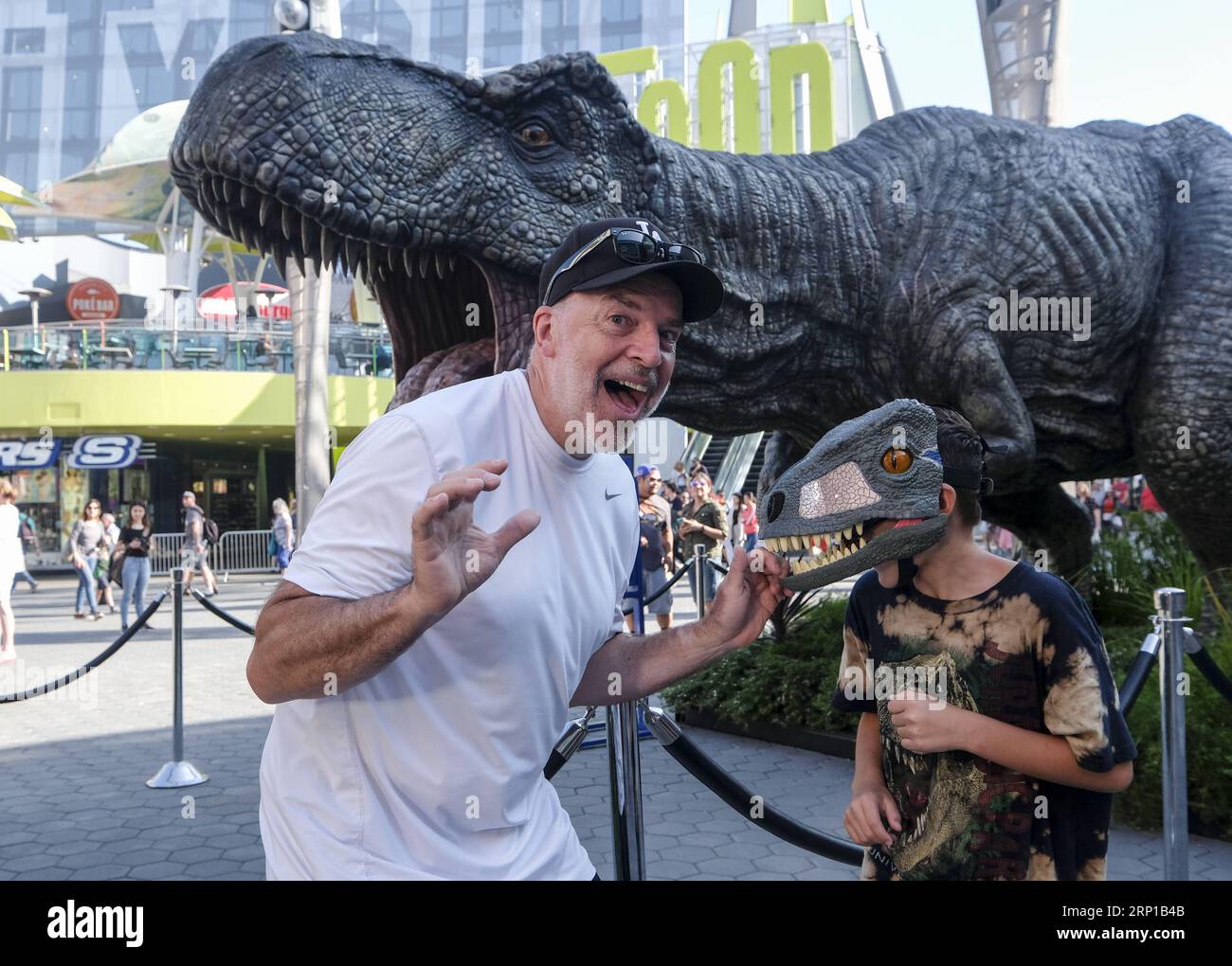 (180622) -- LOS ANGELES, June 22, 2018 -- People pose for pictures with a giant Tyrannosaurus rex statue at Universal CityWalk in Los Angeles, United States on June 21, 2018. For the promotion of the screening of the new film Jurassic World: Fallen Kingdom on Universal Cinema Theatres, a colossal 3-ton Tyrannosaurus rex, a life-sized Gyrosphere original movie prop, as well as original costume, are displayed for public at Universal CityWalk. ) (zxj) U.S.-LOS ANGELES-DINOSAUR-STATUE ZhaoxHanrong PUBLICATIONxNOTxINxCHN Stock Photo
