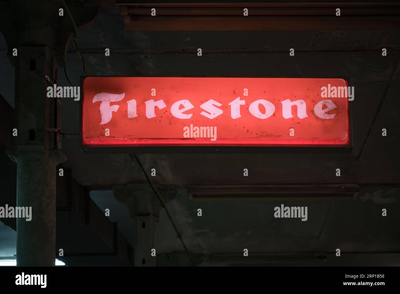 A closeup of an old illuminated sign for Firestone tires in an old workshop Stock Photo
