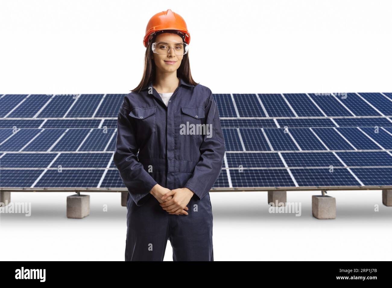 Young female technician with a helmet and goggles posing in front of photovoltaics isolated on white background Stock Photo