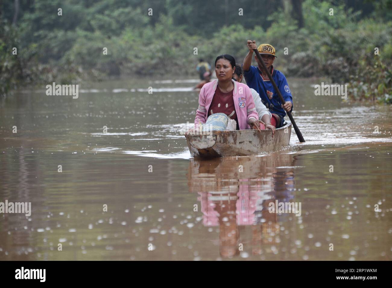 (180726) -- ATTAPEU, July 26, 2018 -- Villagers row a boat in flood