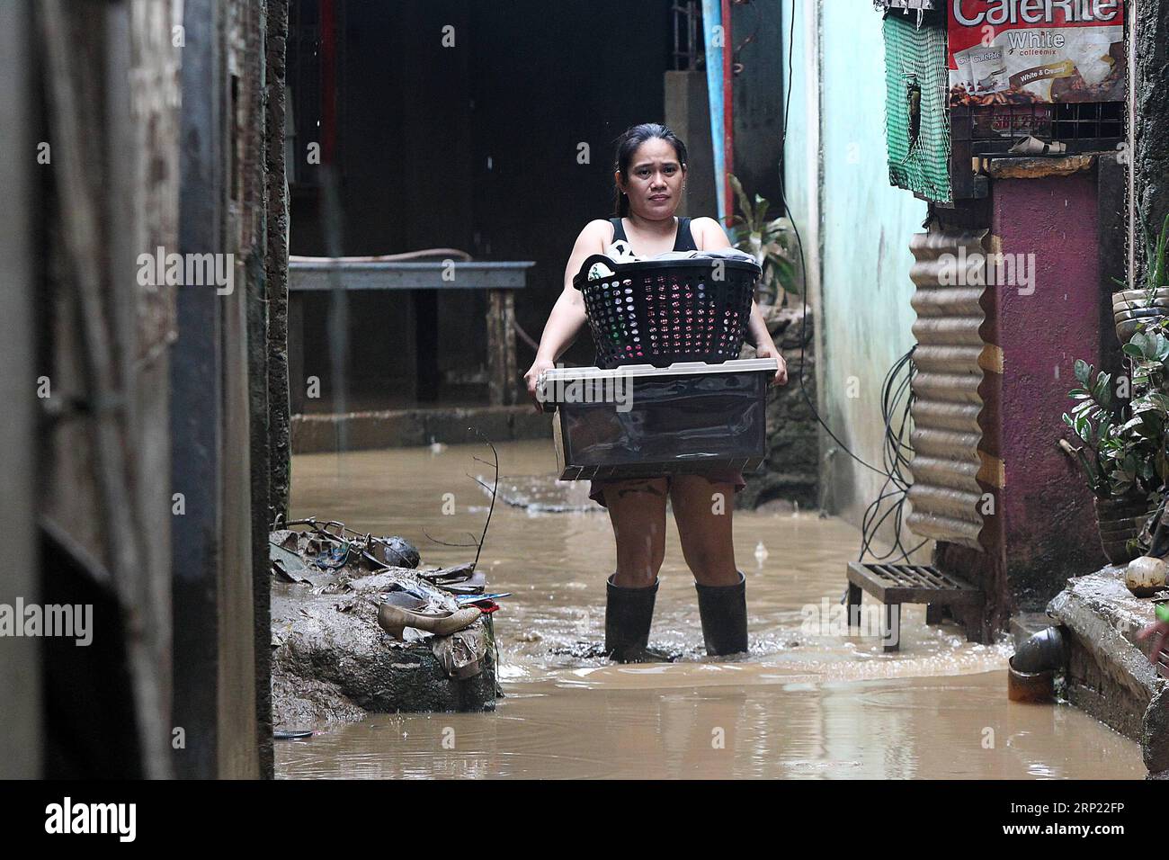 (180813) -- RIZAL, Aug. 13, 2018 -- A woman carries her belongings as she walks through the mud and flood in Rizal Province, the Philippines, Aug. 13, 2018. Days of torrents of rainfall and flooding battered a widespread area in the Philippines, displacing nearly 383,000 people, a disaster agency said on Sunday. ) (jmmn) PHILIPPINES-RIZAL-FLOOD AFTERMATH RouellexUmali PUBLICATIONxNOTxINxCHN Stock Photo