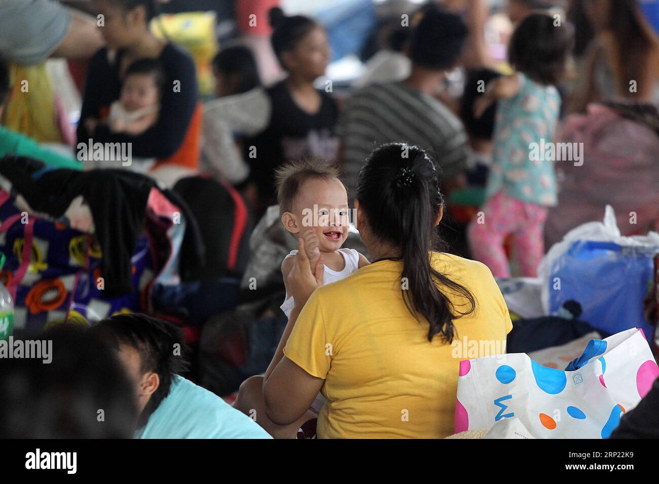 (180813) -- RIZAL, Aug. 13, 2018 -- A mother plays with her child in an evacuation center in Rizal Province, the Philippines, Aug. 13, 2018. Days of torrents of rainfall and flooding battered a widespread area in the Philippines, displacing nearly 383,000 people, a disaster agency said on Sunday. ) (jmmn) PHILIPPINES-RIZAL-EVACUATION CENTER RouellexUmali PUBLICATIONxNOTxINxCHN Stock Photo