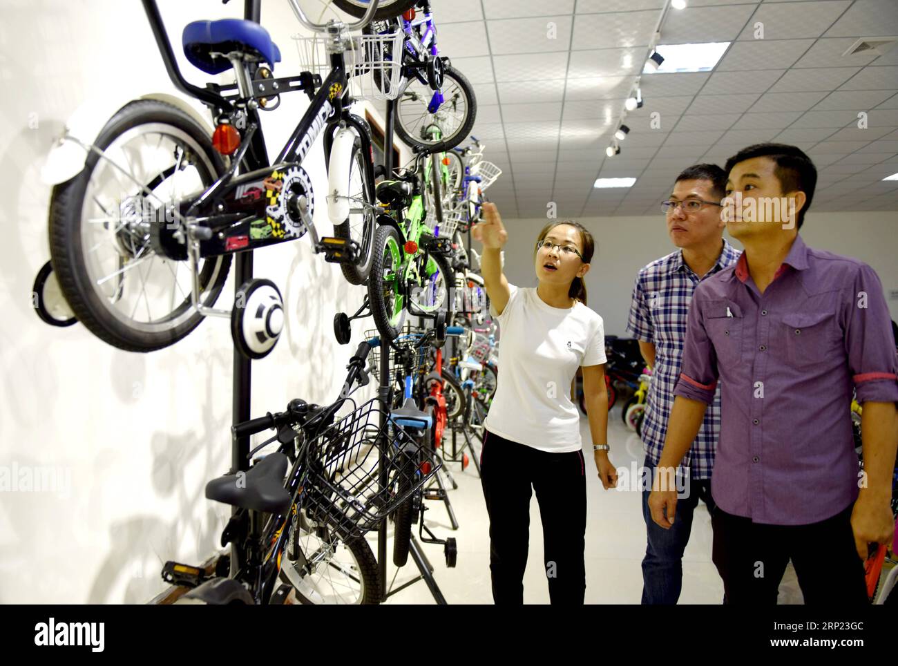 (180815) -- SHIJIAZHUANG, Aug. 15, 2018 -- A worker (L) introduces kids bikes to clients at a factory in Guangzong County, north China s Hebei Province, Aug. 15, 2018. As the local pillar industry, the making of kids bikes in Guangzong started in 1970s. Local government has been encouraging enterprises to develop updated products and enter the global market. Now over 25 million kids bikes of various kinds are produced in the county annually and exported to 30 countries and regions. ) (mp) CHINA-HEBEI-GUANGZONG-KIDS BIKES (CN) ZhuxXudong PUBLICATIONxNOTxINxCHN Stock Photo