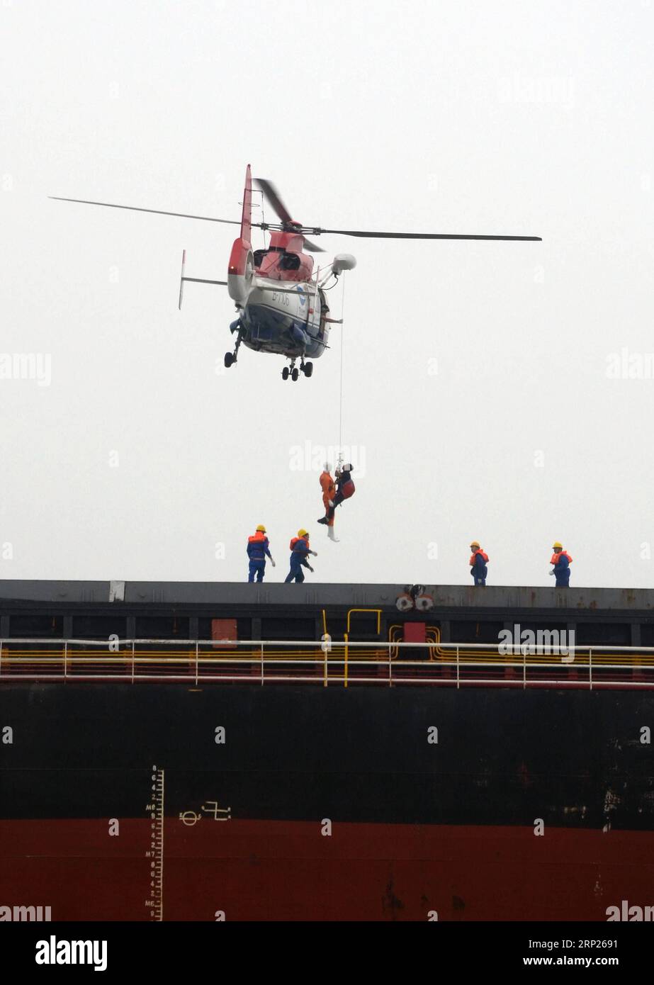 (180821) -- CANGZHOU, Aug. 21, 2018 (Xinhua) -- Rescuers lift an injured personnel onto a helicopter during a maritime emergency drill near the Port of Huanghua in Cangzhou, north China s Hebei Province, Aug. 21, 2018. The maritime safety administrations of Hebei, Tianjin and Shandong held a joint emergency drill in the western Bohai Sea on Tuesday to tackle with search and rescue at sea as well as oil spill response. (Xinhua/Ma Ning)(lmm) CHINA-HEBEI-MARITIME EMERGENCY-DRILL (CN) PUBLICATIONxNOTxINxCHN Stock Photo