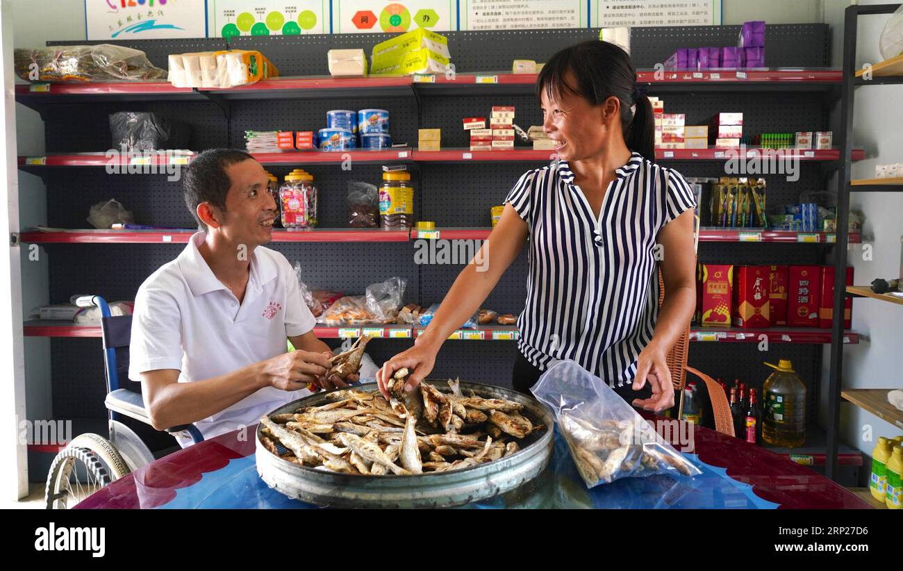 (180823) -- NANCHANG, Aug. 23, 2018 -- Zhang Chunmei and her husband select dried fish at a store in Wan an County, east China s Jiangxi Province, Aug. 21, 2018. Zhang Chunmei has been providing for her family after her husband, Xu Liliang, was diagnosed with Parkinson s disease in 2009. Thanks to her hardworking and the help from others, her family s living standard has improved. Her family decided to take a wedding dress photo to mark their 15 years wedding anniversary. ) (zyd) CHINA-JIANGXI-WEDDING ANNIVERSARY-POVERTY (CN) HuxChenhuan PUBLICATIONxNOTxINxCHN Stock Photo