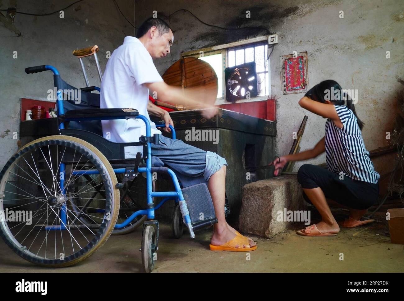 (180823) -- NANCHANG, Aug. 23, 2018 -- Zhang Chunmei cooks with her husband at their home in Wan an County, east China s Jiangxi Province, Aug. 21, 2018. Zhang Chunmei has been providing for her family after her husband, Xu Liliang, was diagnosed with Parkinson s disease in 2009. Thanks to her hardworking and the help from others, her family s living standard has improved. Her family decided to take a wedding dress photo to mark their 15 years wedding anniversary. ) (zyd) CHINA-JIANGXI-WEDDING ANNIVERSARY-POVERTY (CN) HuxChenhuan PUBLICATIONxNOTxINxCHN Stock Photo
