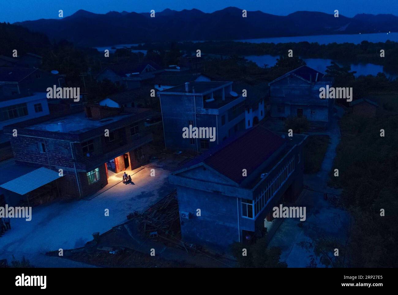 (180823) -- NANCHANG, Aug. 23, 2018 -- Aerial photo shows Zhang Chunmei and her husband rest outside their home in Wan an County, east China s Jiangxi Province, Aug. 21, 2018. Zhang Chunmei has been providing for her family after her husband, Xu Liliang, was diagnosed with Parkinson s disease in 2009. Thanks to her hardworking and the help from others, her family s living standard has improved. Her family decided to take a wedding dress photo to mark their 15 years wedding anniversary. ) (zyd) CHINA-JIANGXI-WEDDING ANNIVERSARY-POVERTY (CN) HuxChenhuan PUBLICATIONxNOTxINxCHN Stock Photo