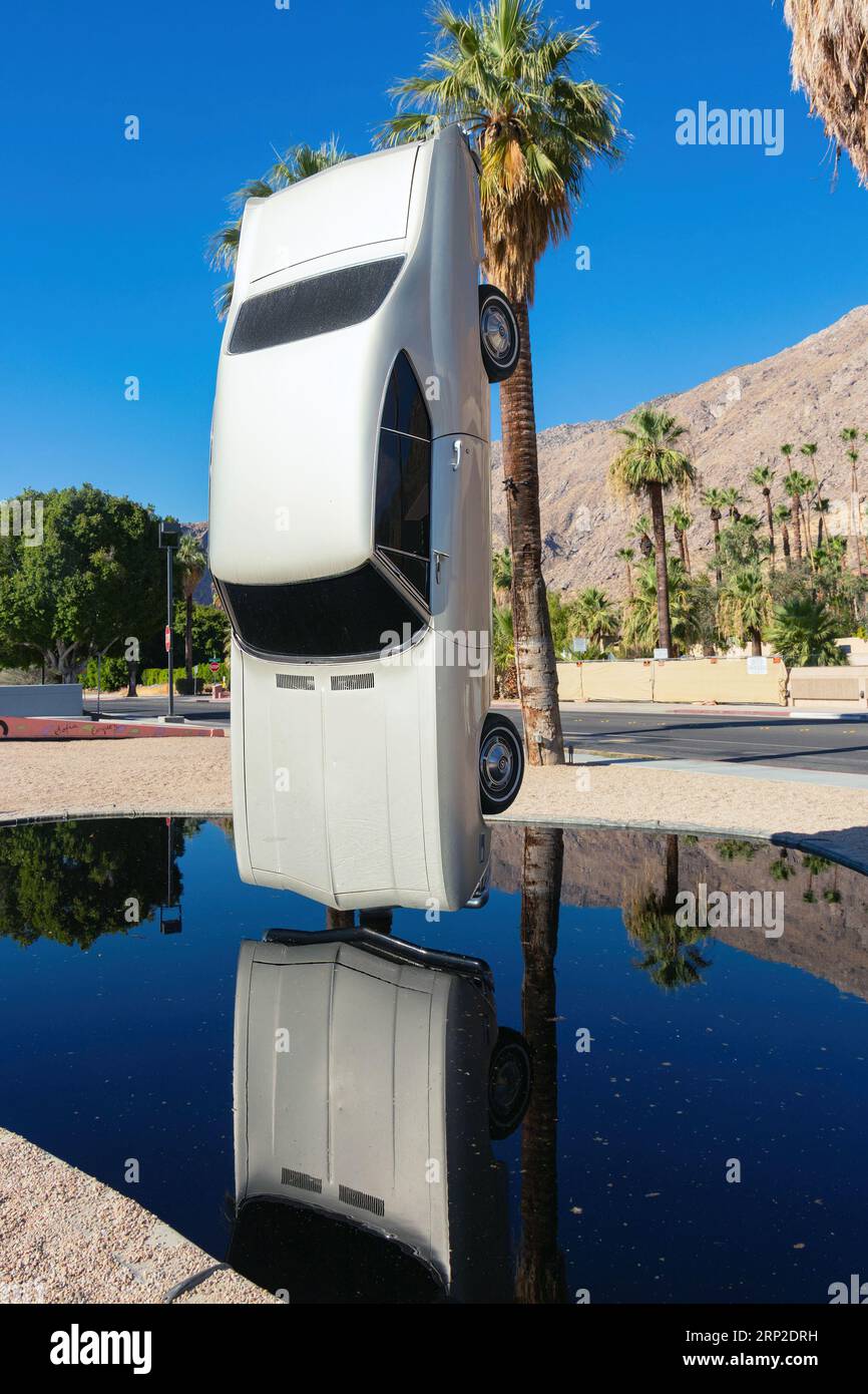 History of Suspended Time Sculpture by Gonzalo Lebrija - upright vertical car sculpture reflecting in pool outside Palm springs Art museum Stock Photo