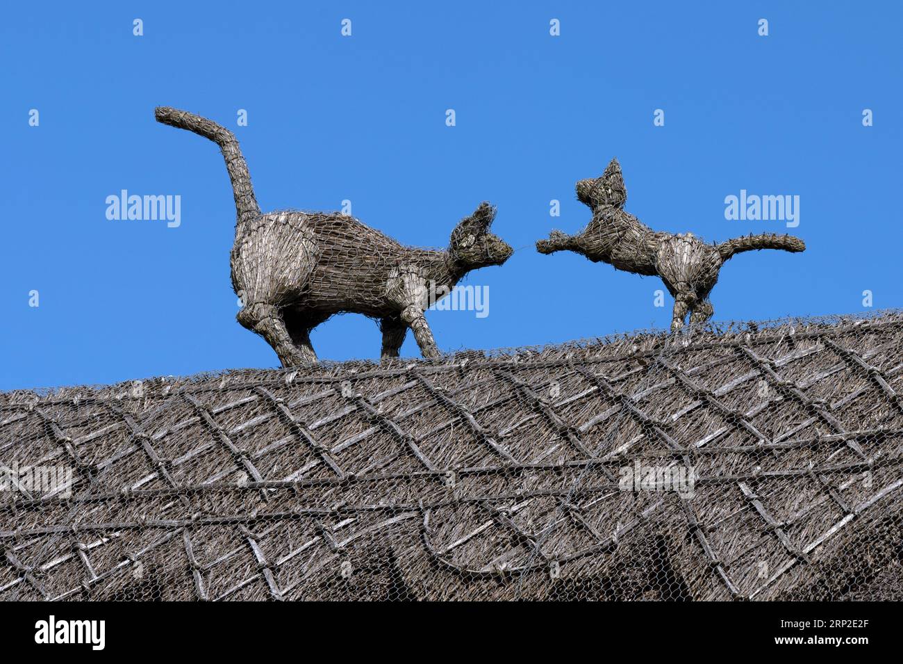 Cat sculptures on a thatched roof Stock Photo