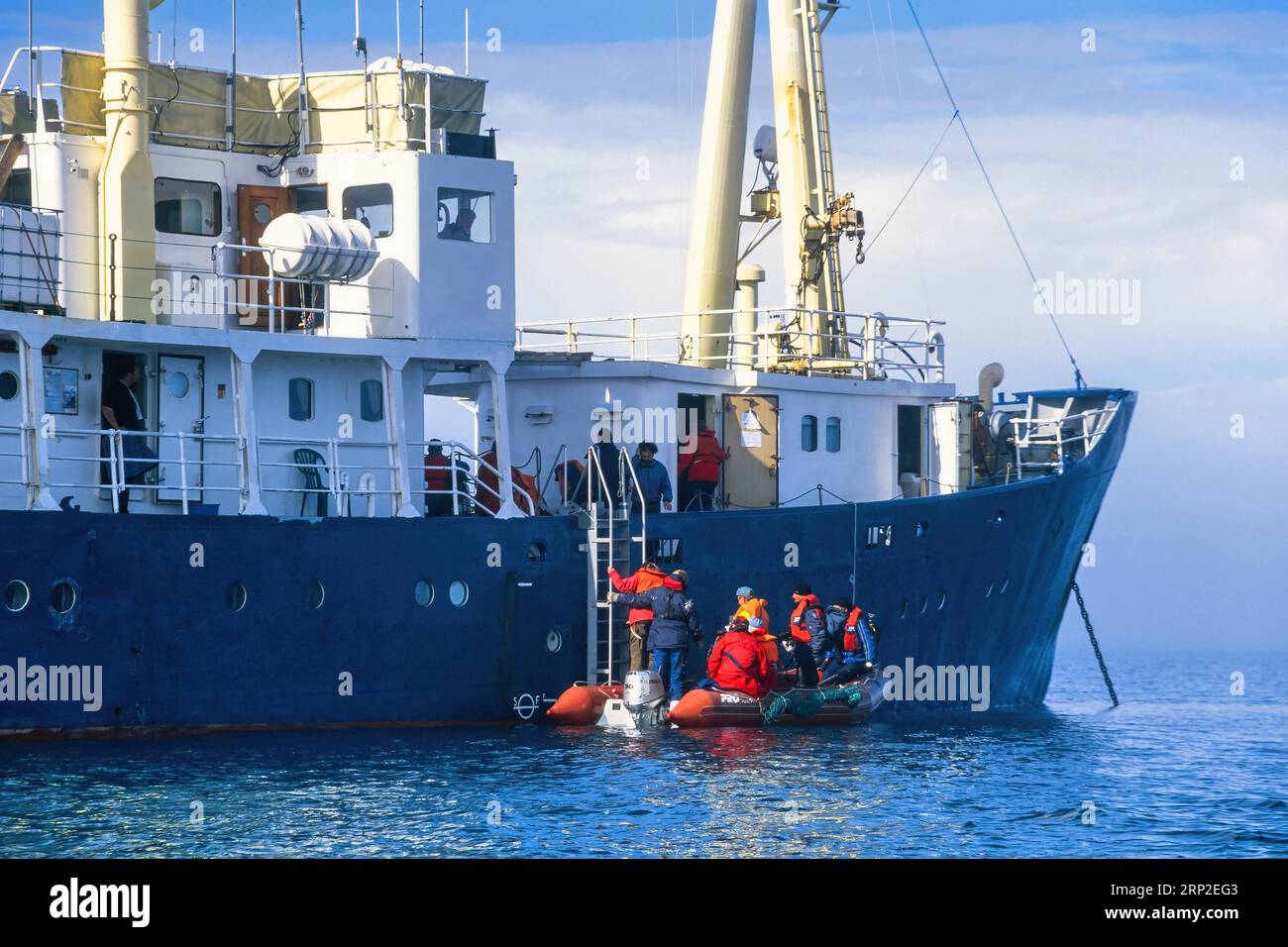 People climbing aboard a ship from an inflatable boat, Svalbard Stock Photo Alamy