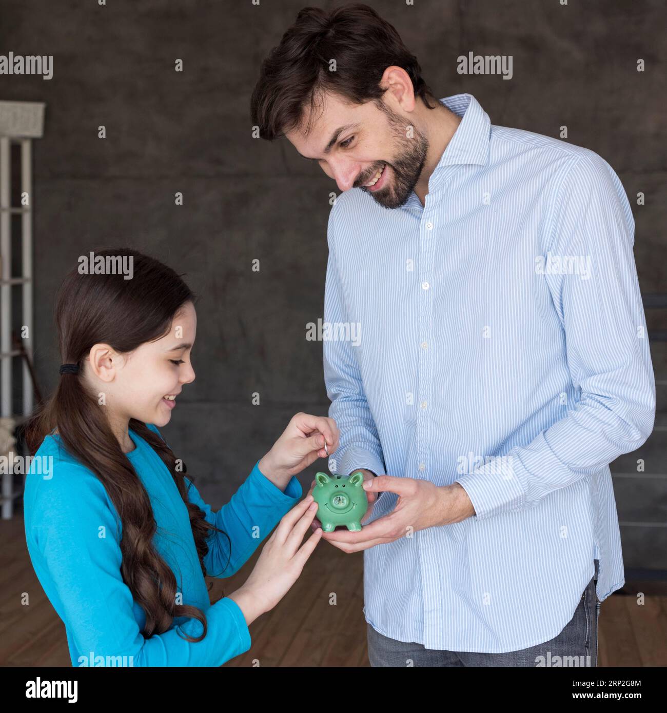 High angle father daughter with piggy bank Stock Photo - Alamy