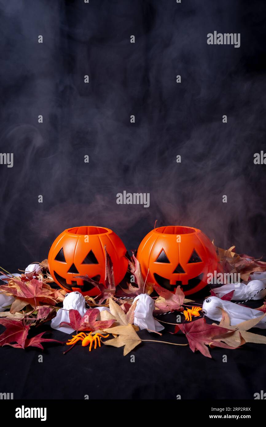 Halloween pumpkins over red autumn leaves and ghosts with smoke on a ...