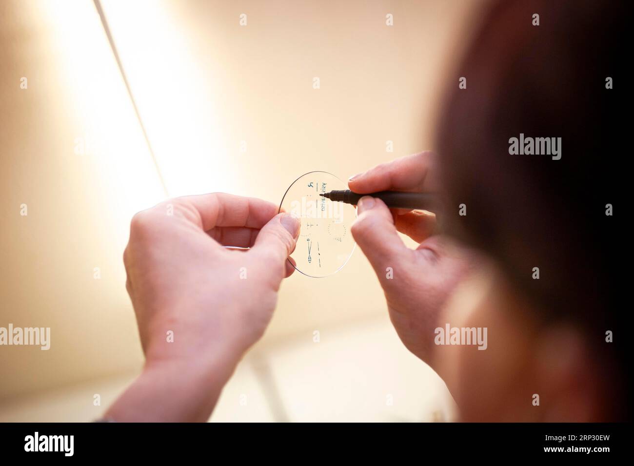 An optician inscribes a spectacle lens Stock Photo