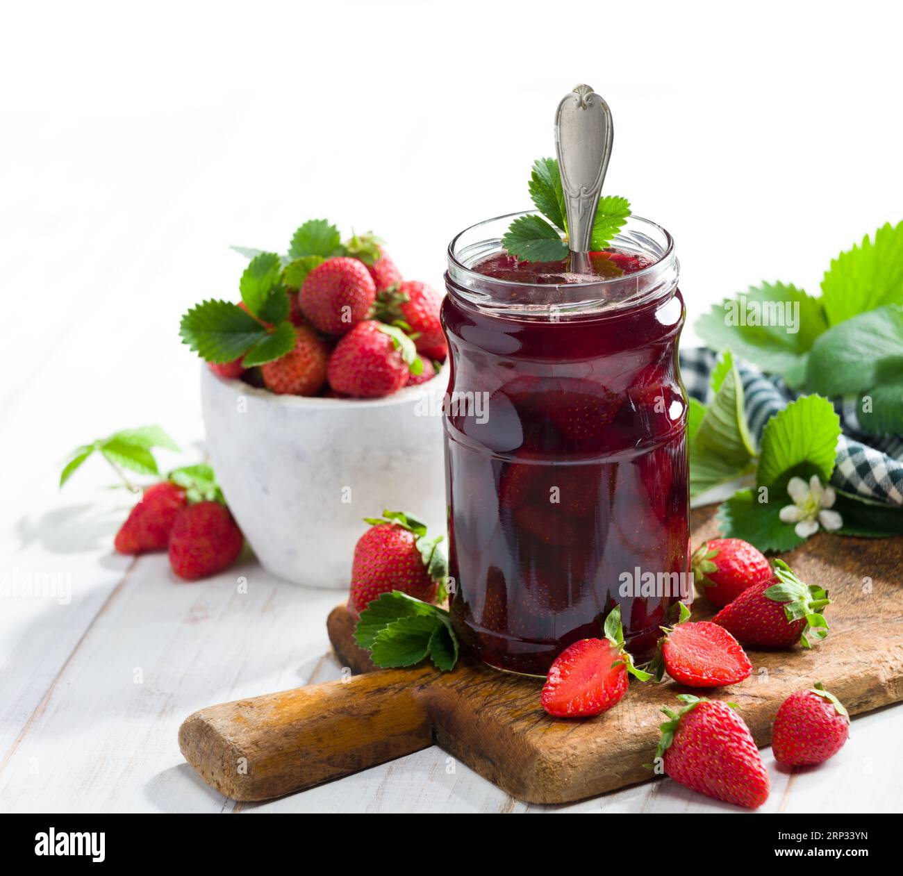 Strawberry jam. Strawberries and a jar of strawberry jam on a white wooden table. Stock Photo