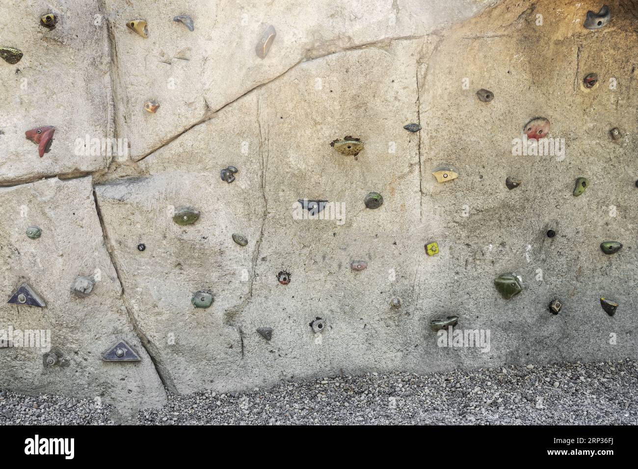 A rock wall in a park with holds for climbing Stock Photo