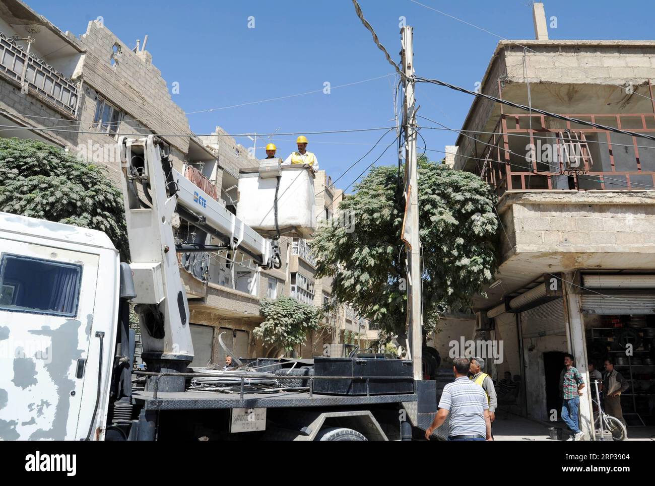 (180925) -- DAMASCUS, Sept. 25, 2018 -- Electricity workers install new electricity lines in the formerly rebel-held areas in Eastern Ghouta near Damascus, Syria, on Sept. 25, 2018. The Syrian government has started rehabilitating the electricity sector in Eastern Ghouta after the Syrian army captured the towns and villages in that region in May. ) SYRIA-EASTERN GHOUTA-ELECTRICITY-REHABILITATION AmmarxSafarjalani PUBLICATIONxNOTxINxCHN Stock Photo