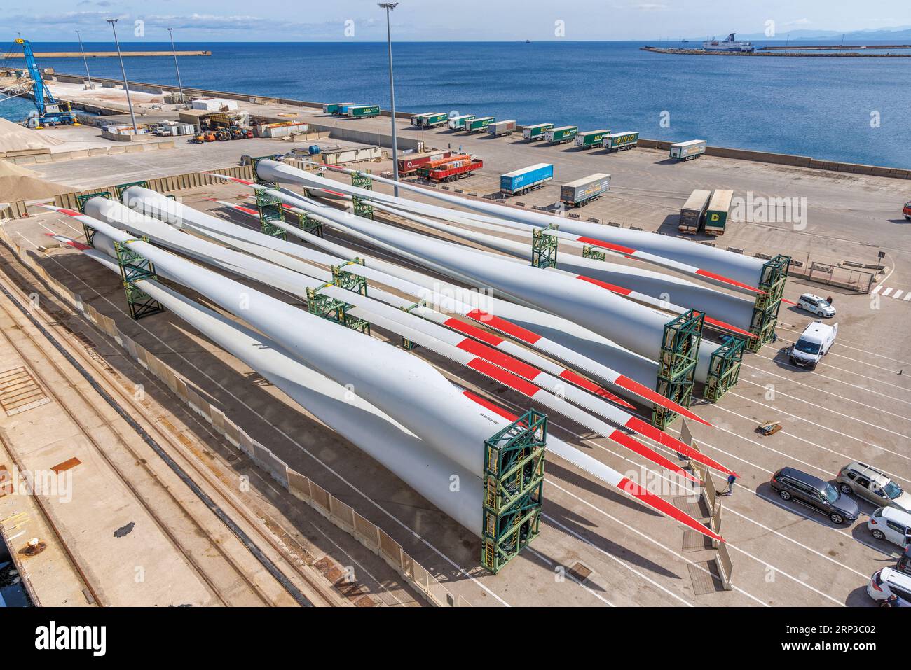 Porto Torres, Sardinia, Italy.  Industrial zone.  Cars and wind turbine rotor blades waiting for loading onto ship. Stock Photo
