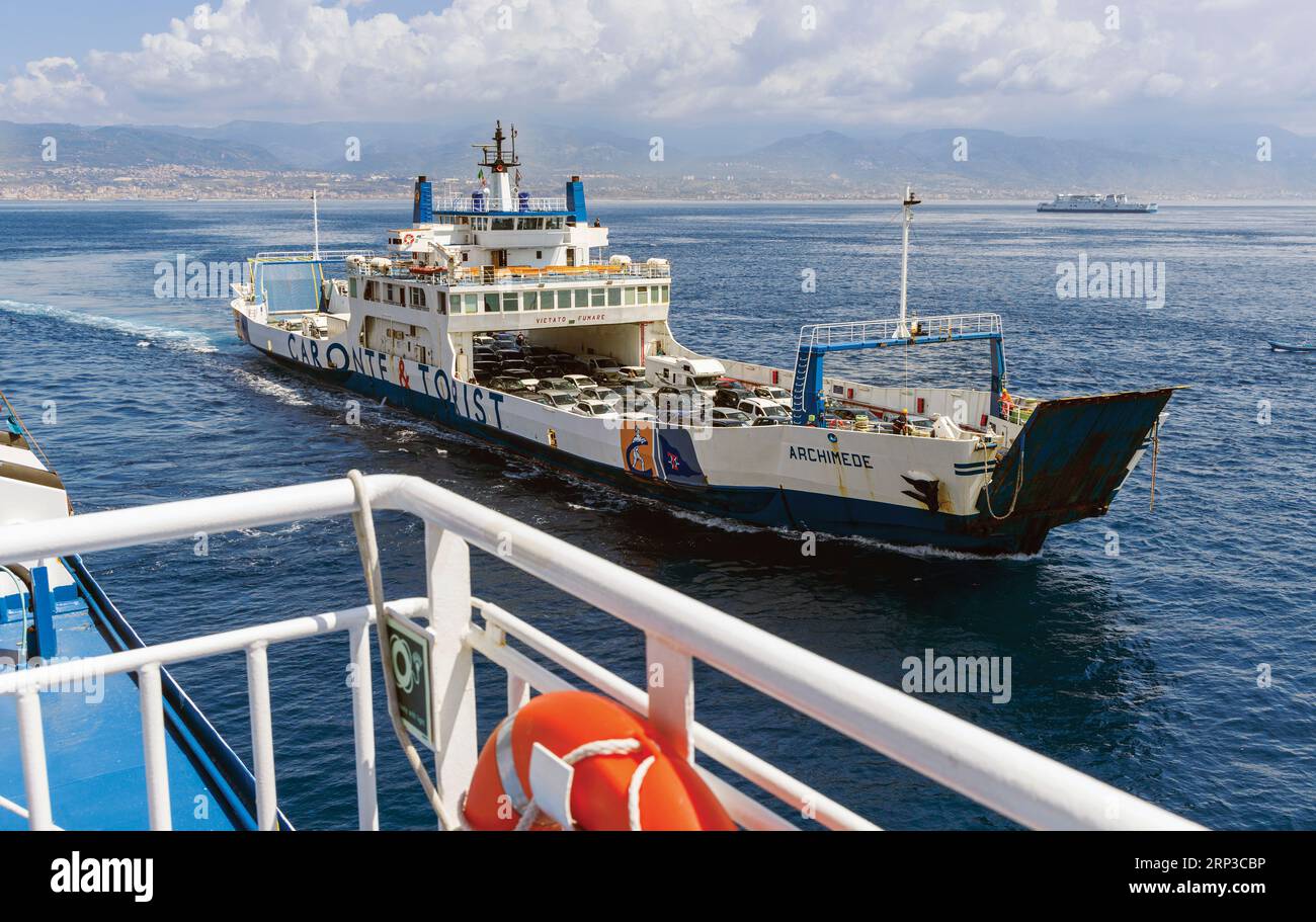 Car ferry in the Strait of Messina approaching Villa San Giovanni, Calabria, Italy from Messina, Sicily, seen in background. Stock Photo