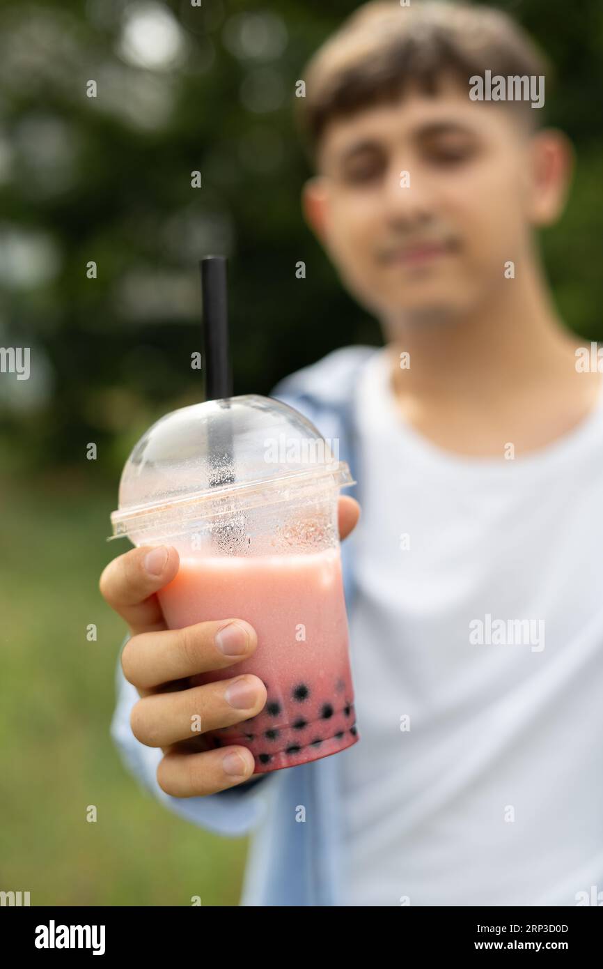 Young man drinking bubble tea and enjoy summer vacation showing plastic