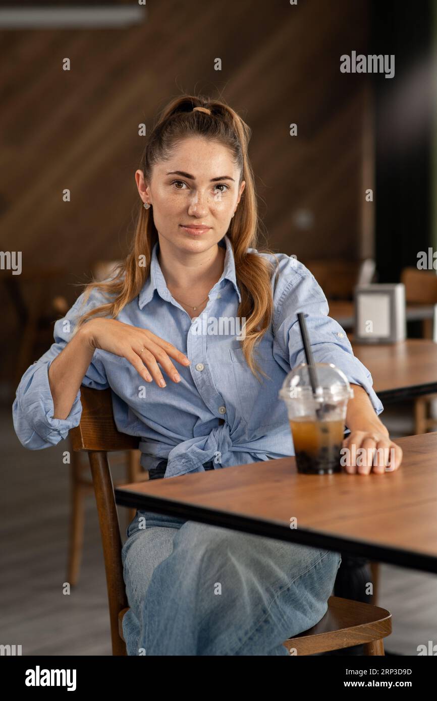 Portrait of a young girl in a restaurant with a glass of bubble tea