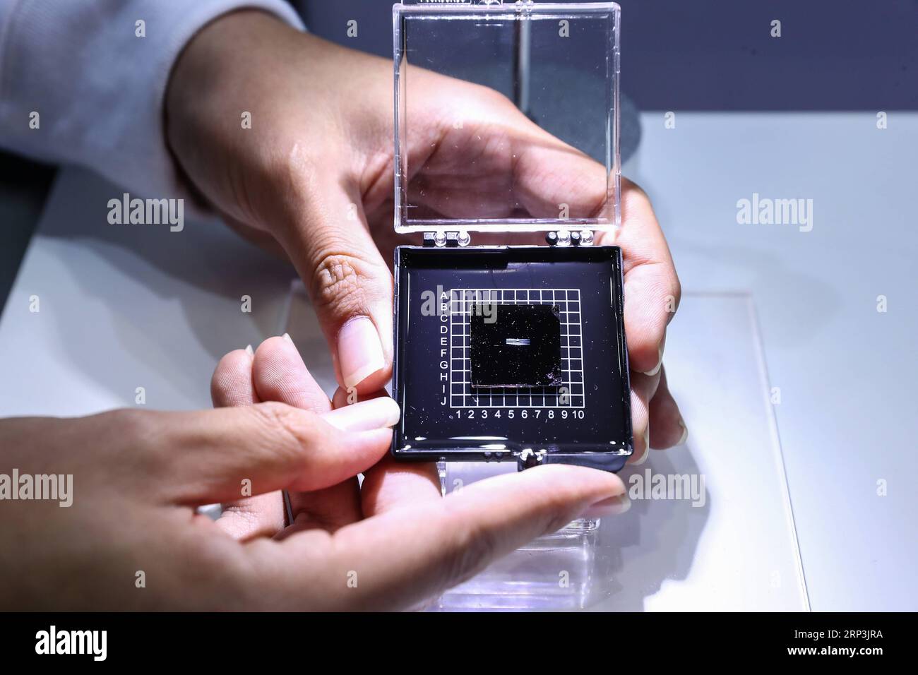 (181008) -- BEIJING, Oct. 8, 2018 -- A staff member shows a photonic AI chip during a press preview of the 2018 National Mass Innovation and Entrepreneurship Week in Beijing, capital of China, Oct. 8, 2018. The weekly event will run from October 9 to 15. ) (lmm) CHINA-BEIJING-TECHNOLOGY-INNOVATION-ENTREPRENEURSHIP (CN) ZhangxYuwei PUBLICATIONxNOTxINxCHN Stock Photo
