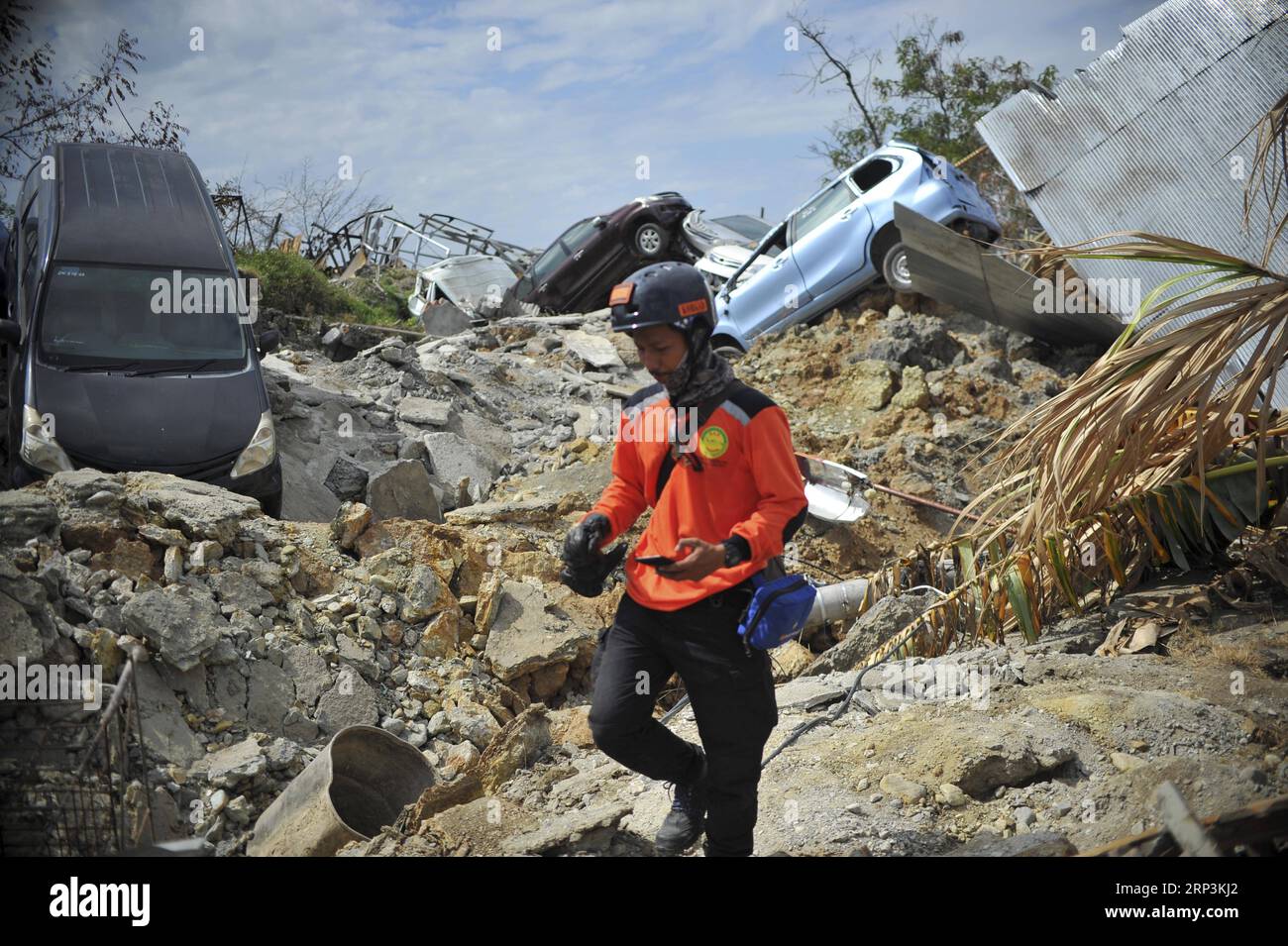 (181010) -- POSO, Oct. 10, 2018 -- An Indonesian rescuer walks on dried mud in Poso, Central Sulawesi Province, Indonesia, on Oct. 9, 2018. The earthquakes and the tsunami have killed at least 2,010 people, left over 5,000 others missing and triggered massive damage and a huge evacuation, according to the national disaster management agency. ) (yy) INDONESIA-POSO-EARTHQUAKE AND TSUNAMI-AFTERMATH Zulkarnain PUBLICATIONxNOTxINxCHN Stock Photo