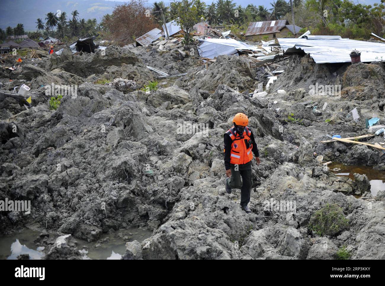 (181010) -- POSO, Oct. 10, 2018 -- An Indonesian rescuer walks on dried mud in Poso, Central Sulawesi Province, Indonesia, on Oct. 9, 2018. The earthquakes and the tsunami have killed at least 2,010 people, left over 5,000 others missing and triggered massive damage and a huge evacuation, according to the national disaster management agency. ) (yy) INDONESIA-POSO-EARTHQUAKE AND TSUNAMI-AFTERMATH Zulkarnain PUBLICATIONxNOTxINxCHN Stock Photo