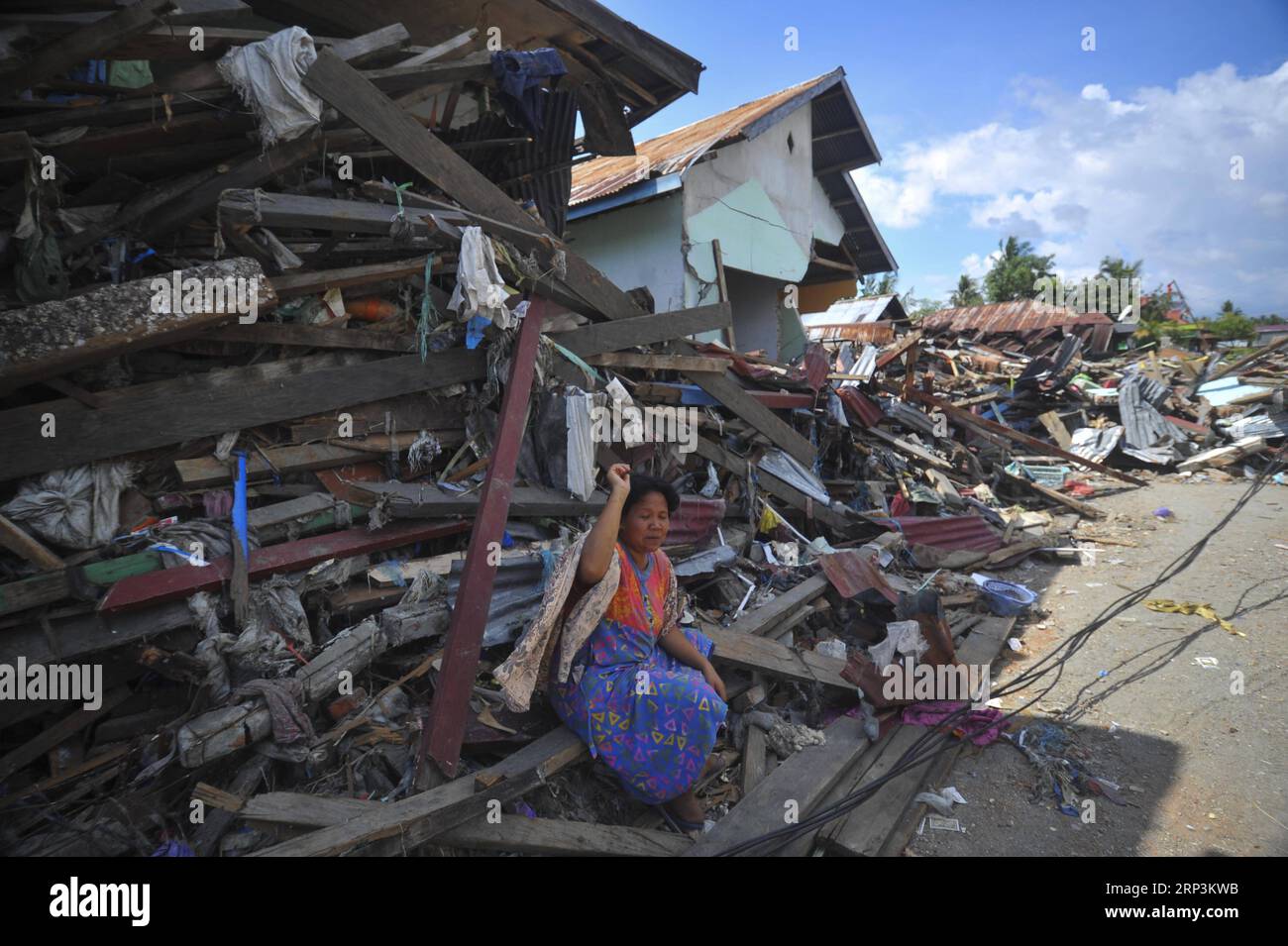 (181010) -- POSO, Oct. 10, 2018 -- An Indonesian woman sits on debris near her house after an earthquake and tsunami at Pantoloan port in Poso, Central Sulawesi Province, Indonesia, on Oct. 10, 2018. The earthquakes and the tsunami have killed at least 2,010 people, left over 5,000 others missing and triggered massive damage and a huge evacuation, according to the national disaster management agency. ) (dtf) INDONESIA-POSO-EARTHQUAKE AND TSUNAMI-AFTERMATH Zulkarnain PUBLICATIONxNOTxINxCHN Stock Photo