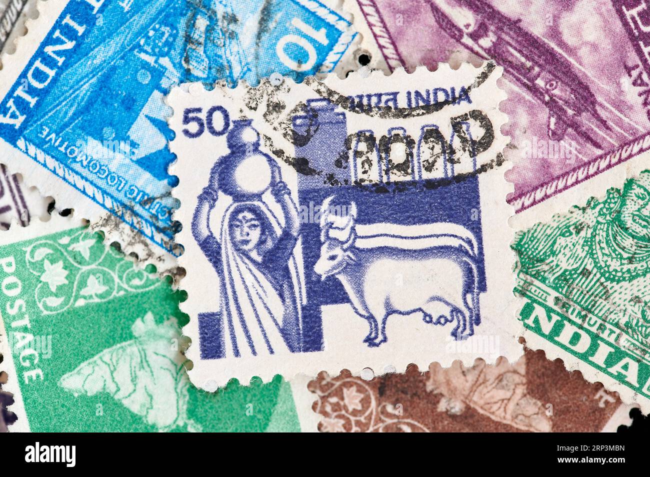 Madrid, Spain; 08-13-2023: Postage stamp from India with a drawing of a woman carrying a pitcher on her head with a cow, a sacred animal in Indian cul Stock Photo