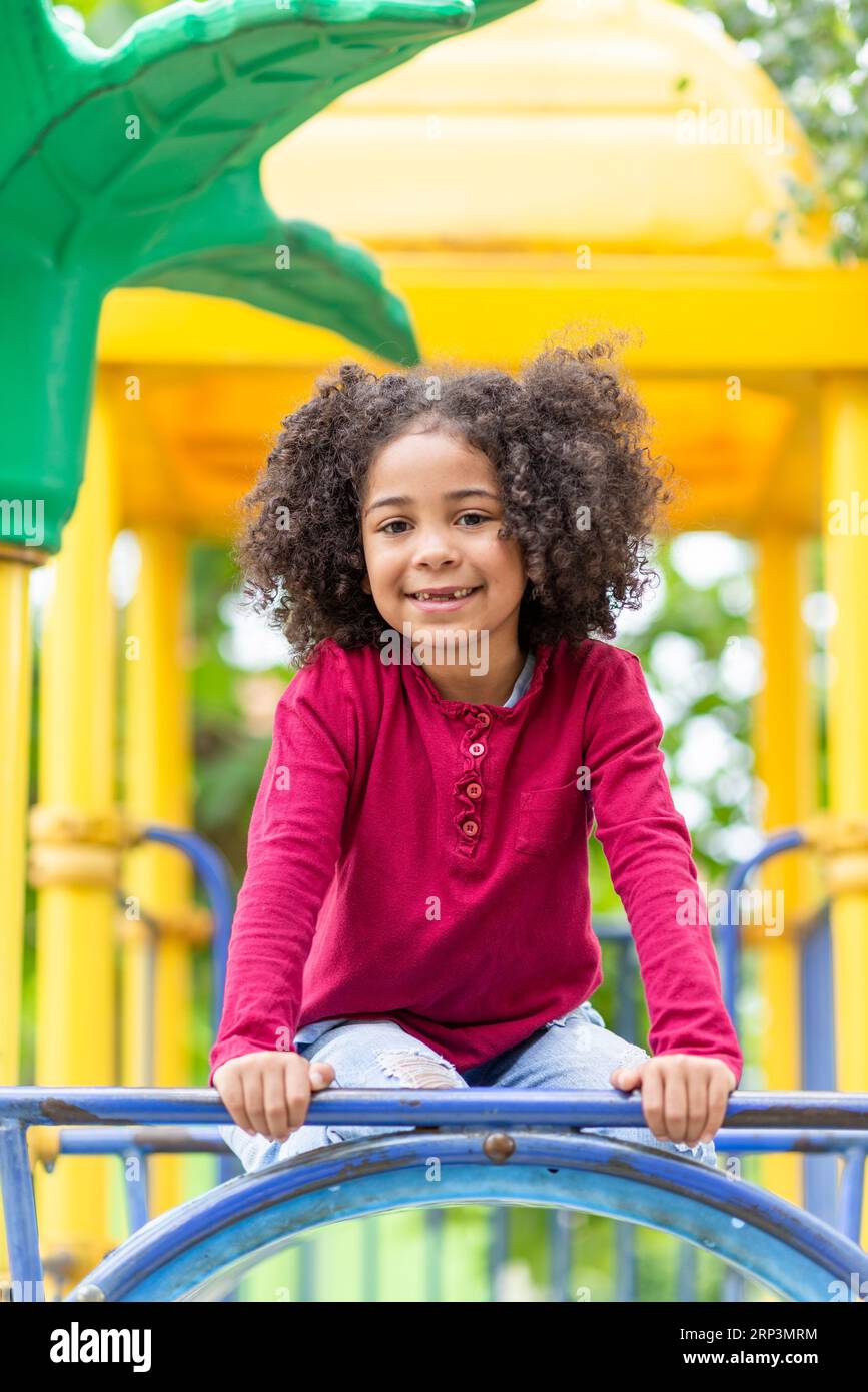 Smiling cute little african american girl with curly hair looking at ...