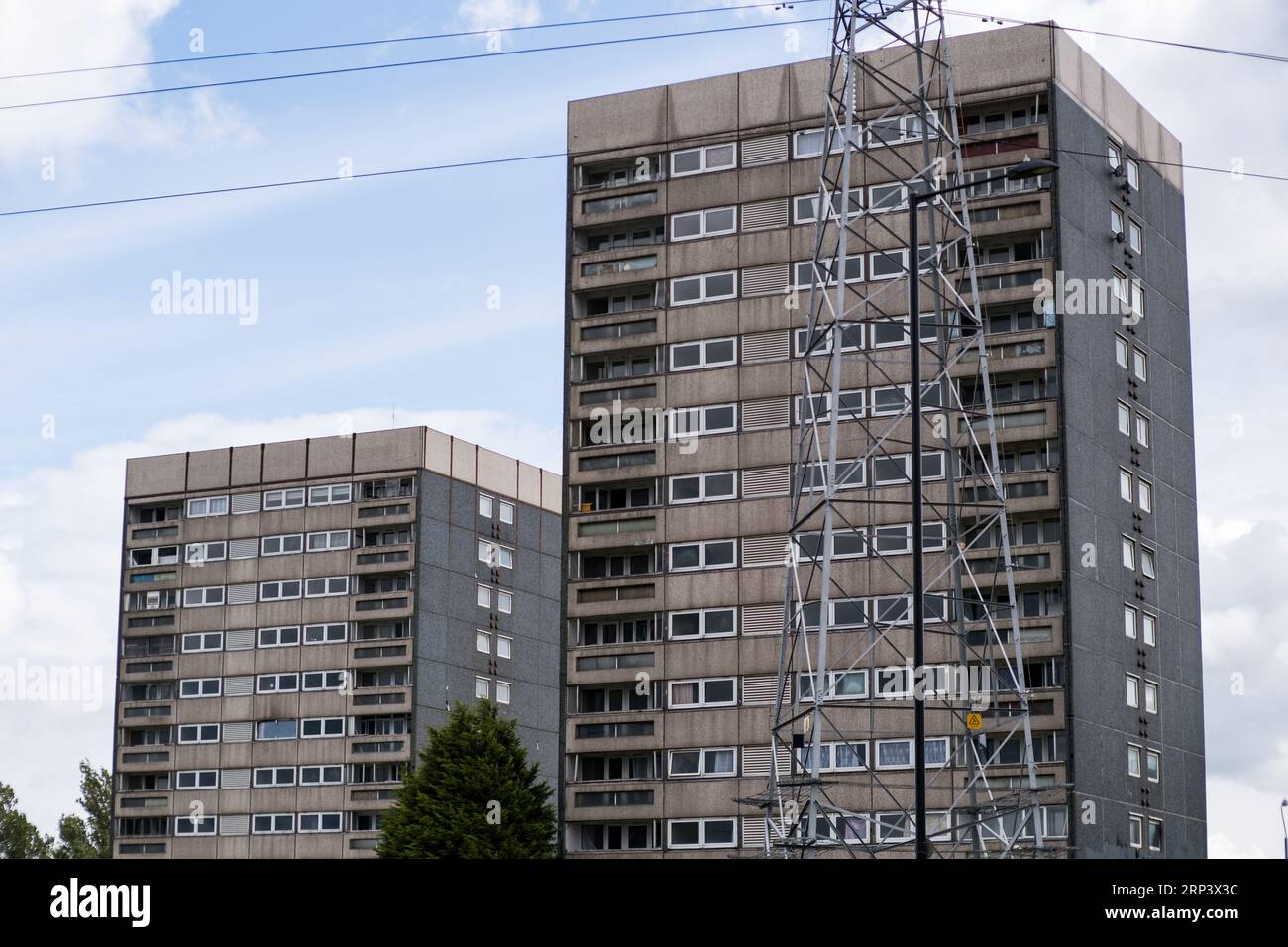 Two derelict and abandoned tower blocks with a pylon in front ...