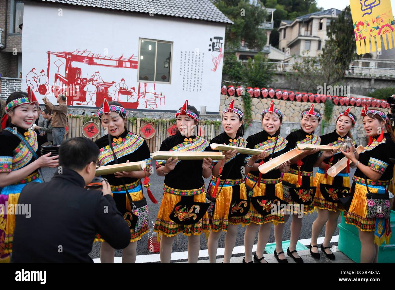 (181018) -- TONGLU, Oct. 18, 2018 (Xinhua) -- Local residents dressed in traditional costumes toast a tourist taking part in the long-table banquet held at Longfeng Ethnic Village in Eshan Township of the She ethnic group of Tonglu County, east China s Zhejiang Province, Oct. 17, 2018. A total of 100 tables of delicacies were presented at the long-table banquet along a street held at the village, attracting local residents as well as tourists to enjoy the food of the She ethnic group. (Xinhua/Huang Zongzhi)(sxk) CHINA-ZHEJIANG-TONGLU-LONG-TABLE BANQUET (CN) PUBLICATIONxNOTxINxCHN Stock Photo