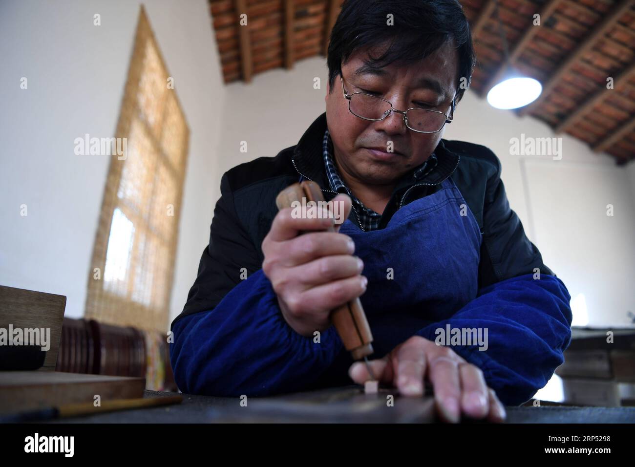 (181124) -- JINGXIAN, Nov. 24, 2018 -- Lei Shitai works in Chanshan Village of Qinxi Town, Jingxian County, in east China s Anhui Province, Nov. 23, 2018. Lei, 52, born in neighboring Jiangxi Province, started his career as a typography printer when he finished his apprenticeship with his uncle who he followed since he was 17. The traditional printing method witnessed an increasingly hard time in the recent years as a livelihood. It was in 2017 when he decided to move to Chanshan at the invitation of Kai Yuanhong, a local cabinet maker, to cooperate in a broader way. Lei is now working with th Stock Photo