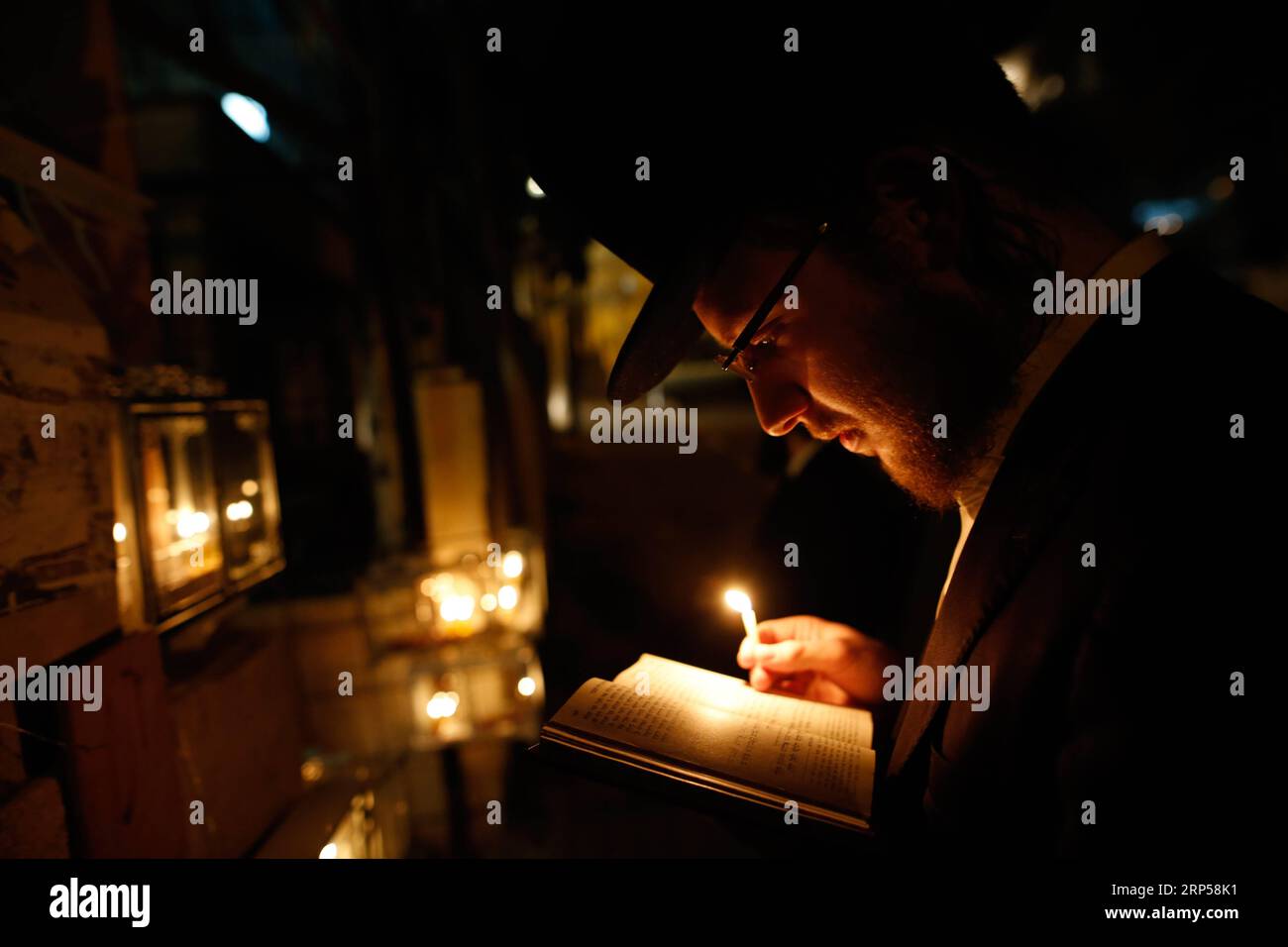 (181203) -- JERUSALEM, Dec. 3, 2018 -- An ultra-Orthodox Jewish man holds a candle during Hanukkah in Mea Shearim neighborhood in Jerusalem, on Dec. 3, 2018. Hanukkah, also known as the Festival of Lights and Feast of Dedication, is an eight-day Jewish holiday commemorating the rededication of the Holy Temple (the Second Temple) in Jerusalem at the time of the Maccabean Revolt against the Seleucid Empire of the 2nd Century B.C. ) MIDEAST-JERUSALEM-HANUKKAH GilxCohenxMagen PUBLICATIONxNOTxINxCHN Stock Photo