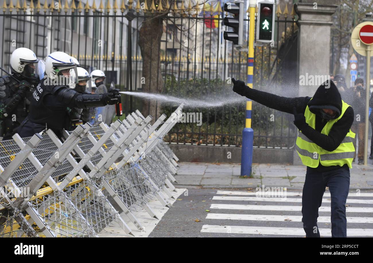 (181208) -- BRUSSELS, Dec. 8, 2018 -- A Police officer squirts pepper water to a protester of the Yellow Vests during a demonstration in downtown Brussels, Belgium, Dec. 8, 2018. ) BELGIUM-BRUSSELS-YELLOW VEST-PROTEST YexPingfan PUBLICATIONxNOTxINxCHN Stock Photo