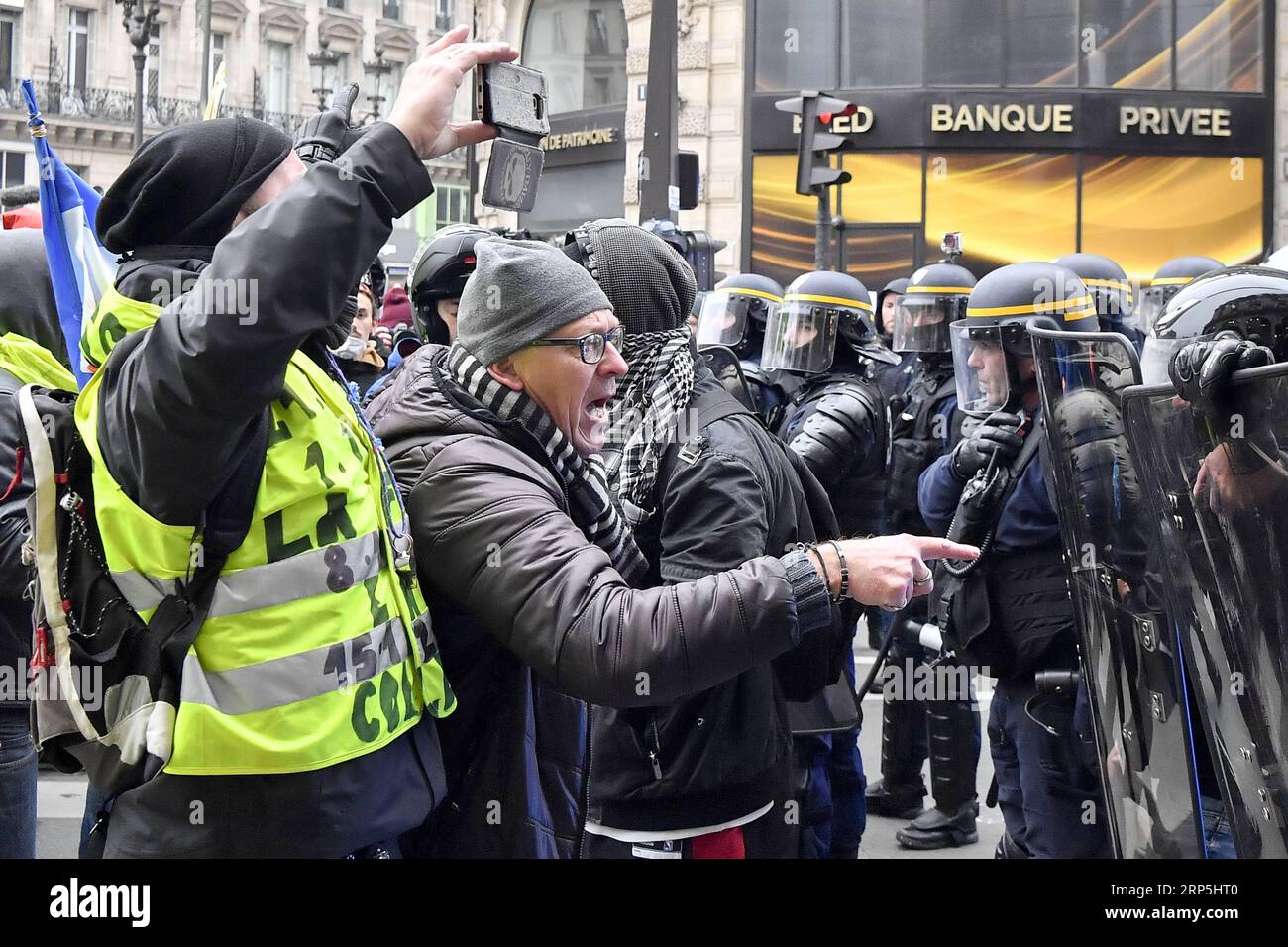 (181215) -- PARIS, Dec. 15, 2018 -- Protesters confront French gendarmes at the Opera Square in Paris, France, on Dec. 15, 2018. French government planned tough security measures by mobilizing thousands of officers and using armored vehicles to handle more threats of violence as Yellow Vests are set to stage a fresh round of nationwide protests on Saturday, despite President Emmanuel Macron s measures seeking to quell public anger over poor revenue and soaring living costs. ) FRANCE-PARIS- YELLOW VESTS -PROTEST ChenxYichen PUBLICATIONxNOTxINxCHN Stock Photo
