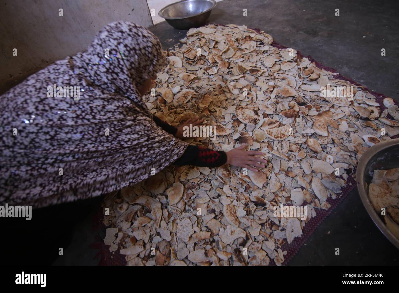 (181218) -- GAZA, Dec. 18, 2018 -- Palestinian woman Fayrouz al-A raj, 45, dries bread remains inside her house, in the southern Gaza Strip city of Khan Younis, on Dec. 18, 2018. Fayrouz al-A raj sells bread remains to livestock owners to feed their animals. ) MIDEAST-GAZA-BREAD-REMAINS KhaledxOmar PUBLICATIONxNOTxINxCHN Stock Photo