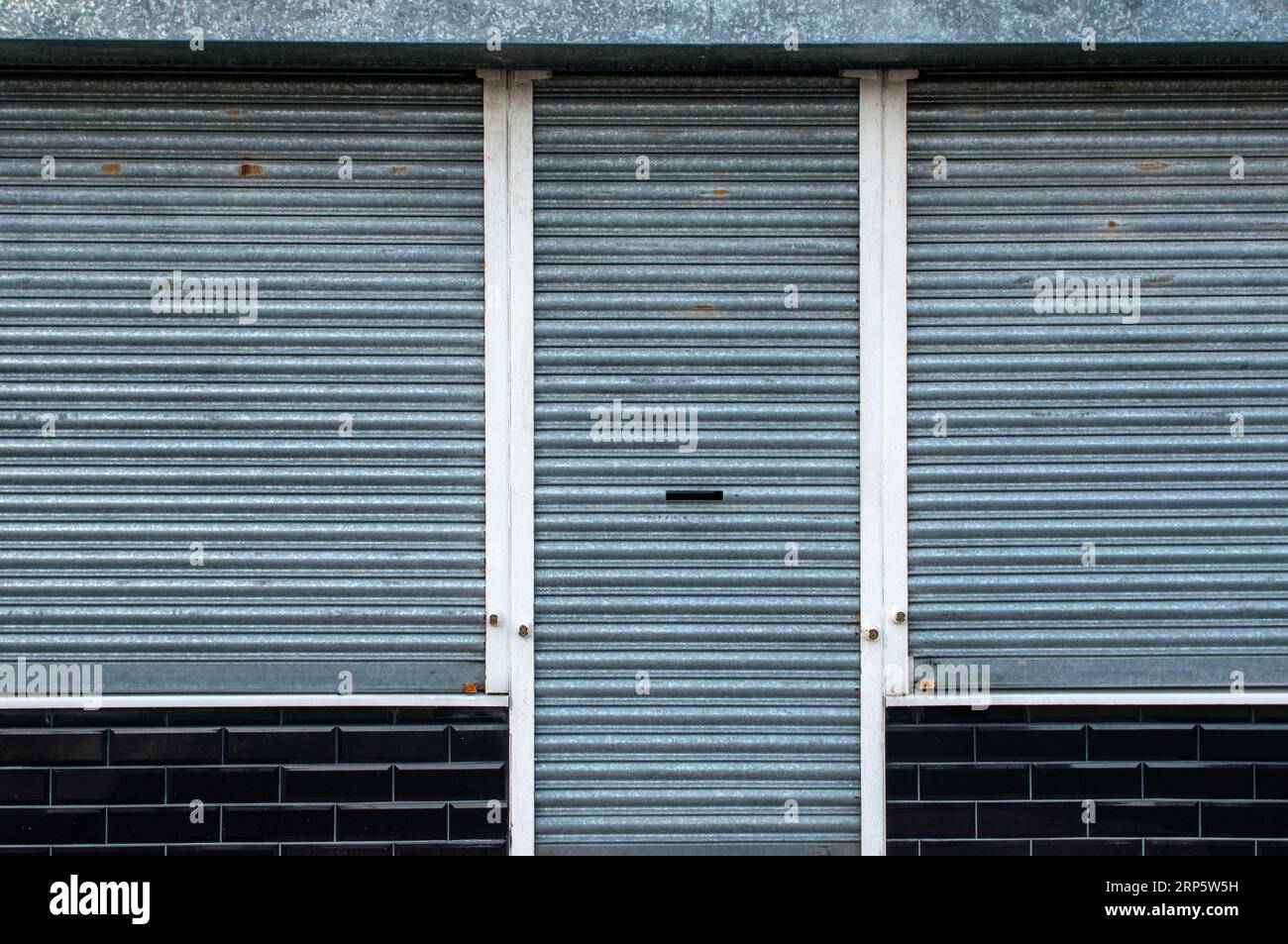 Detail of closed metal security shutters on a shop front in Manchester, England, UK Stock Photo