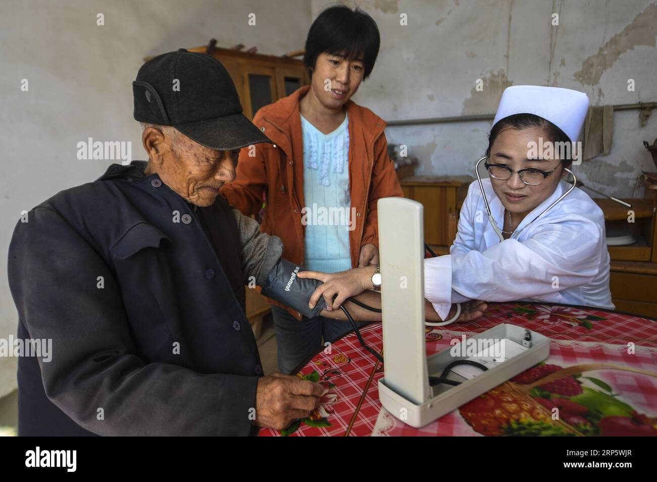 (181225) -- BEIJING, Dec. 25, 2018 -- A nurse checks the blood pressure for a resident at Nanma Village in Gucheng County, north China s Hebei Province, Oct. 29, 2017. The Chinese government spent 5.95 trillion yuan (about 862 billion U.S. dollars) on medical services from 2013 to 2017, with an average annual increase of 11.7 percent, according to a report submitted to National People s Congress, China s top legislature. China s fiscal spending on medical services in 2017 was 1.4 trillion yuan, a 55.5-percent increase from 2013, accounting for 7.1 percent of national fiscal spending. The avera Stock Photo