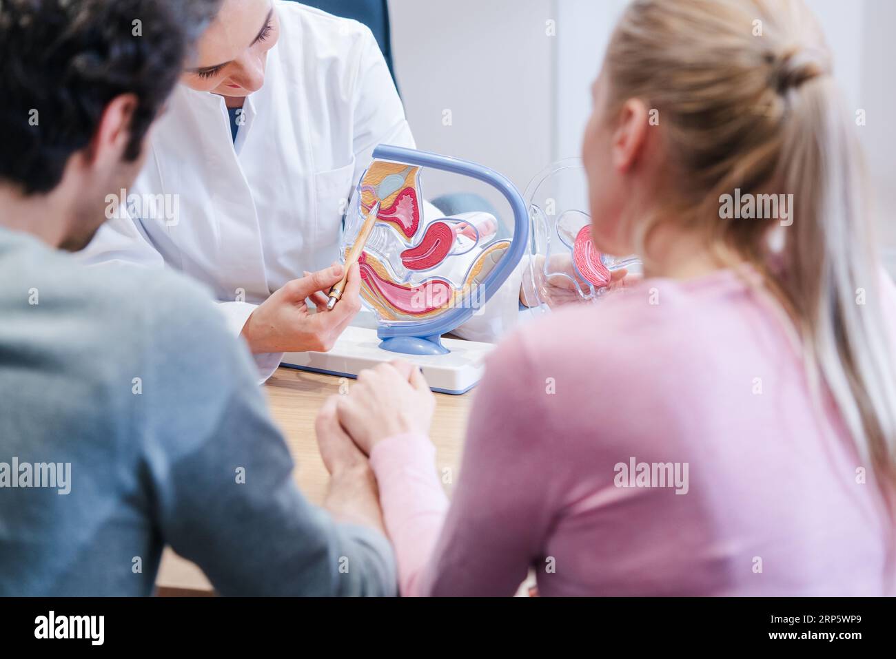 Couple wishing to have children in fertility clinic with doctor Stock Photo