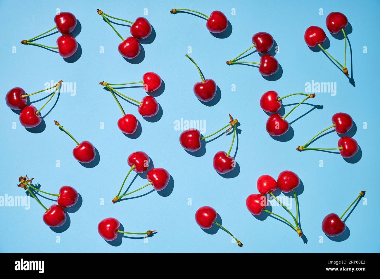 Fresh ripe red cherry with stalks on the blue background. Flat lay. Stock Photo